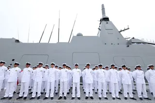 Members of the the Japan Maritime Self-Defense Force stand at attention next to the JS Natori (FFM-9), a Mogami-class stealth frigate, during a handover ceremony and Self-Defense Ship Flag Presentation Ceremony for the Japan Maritime Self-Defense Force (JMSDF) at Mitsubishi Heavy Industries (MHI) Shipyard & Machinery Works in Nagasaki on May 21, 2026. Japan's defence ministry requested a record budget of 8.9 trillion yen ($55.6 billion) on August 31, 2026, as Tokyo looks to artificial intelligen