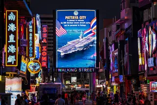 People walk past an LED display welcoming US sailors service personnel from the USS Abraham Lincoln aircraft carrier in Pattaya, Thailand, on Thursday. Photo: Reuters