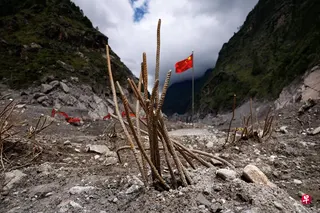 9月6日，洪灾过后，中国西藏自治区日喀则吉隆口岸的原先建筑已荡然无存，救援人员在此插上一面国旗。 （路透社）